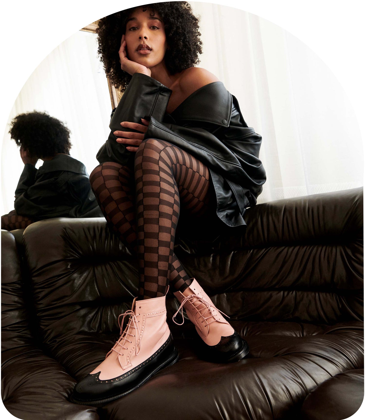 tilda, the long wing fashion boot with a pink leather upper and black wing is shown with a model wearing an oversized black leather jacket and checkered tights
